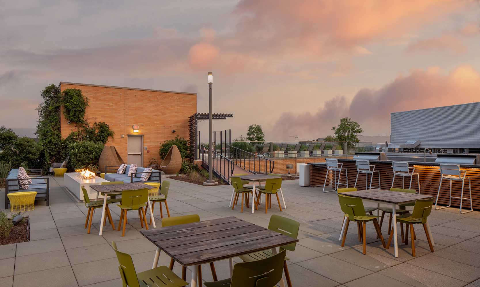 An expansive rooftop sun deck featuring sitting areas and tables for dining